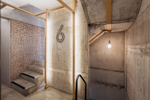 Een trap met een betonnen muur en een houten balkenstructuur.