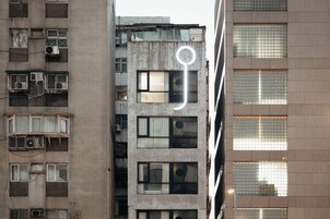 Een meerlaags gebouw met veel ramen en airconditioners.
