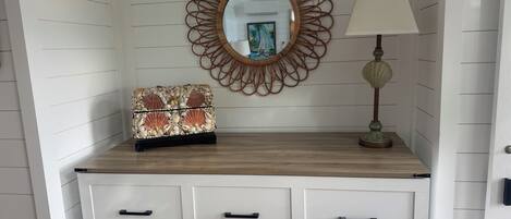 A dresser with drawers, a mirror, a lamp, and a decorative item on top.