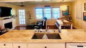 Una cocina con encimera de granito, lavavajillas Bosch, un lavabo y una zona de comedor con mesa y sillas.