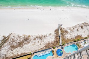 A resort with a beach view, a pool, and a lifeguard tower.