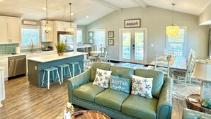 A spacious kitchen with a central island, bar stools, and a dining area with a wooden table and chairs. - Steps away from Grayton Beach, Large Private Saltwater Pool, 4 Bedrooms, 4 Baths (Santa Rosa Beach)