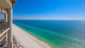 A beachfront hotel with a balcony overlooking a clear blue sea and a sandy beach. - The Oasis at Orange Beach, formerly known as Phoenix West II, Unit 2308 (Orange Beach)