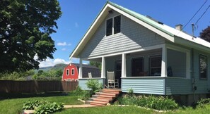 A single-story house with a porch, a red barn in the background, and a clear sky. - Looking to hike, swim or enjoy the mountain views? This is the place for you! (Bartlett)