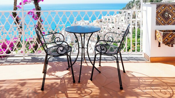 Une terrasse avec une table et des chaises, offrant une vue sur la côte.