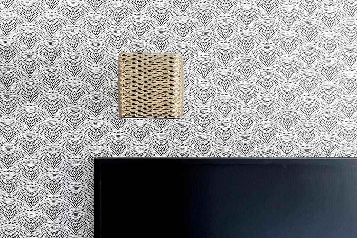 Eine Wand mit geometrischem Muster und einer strukturierten Wandverkleidung.