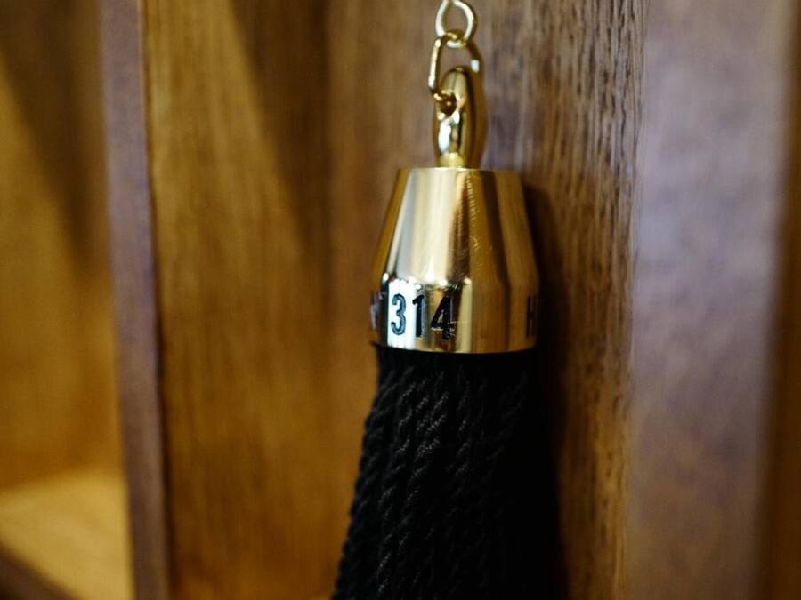 A wooden shelf with a metal keychain hanging from it.