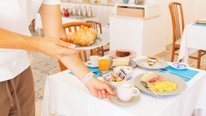 A breakfast setting with a plate of croissant, scrambled eggs, and toast, a cup of coffee, and a glass of orange juice on a table. - Hotel Marconi (Sperlonga)