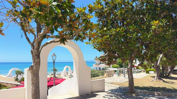 A paved pathway with an archway leading to a view of the sea. - Hotel Marconi (Sperlonga)