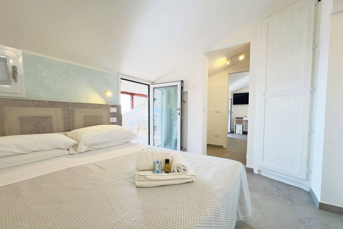 Una habitación de hotel con cama, baño y escritorio.