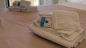 A hotel room with a bed, a nightstand, and a view of the beach. - Hotel Marconi (Sperlonga)