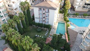 A hotel with a pool, lounge chairs, and a garden area. - The S Apart & Suites Hotel  (Alanya)