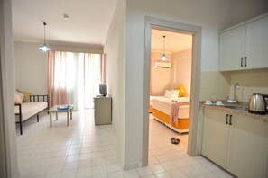 A hotel room with a bed, a desk, a television, and a kitchenette. - The S Apart & Suites Hotel  (Alanya)