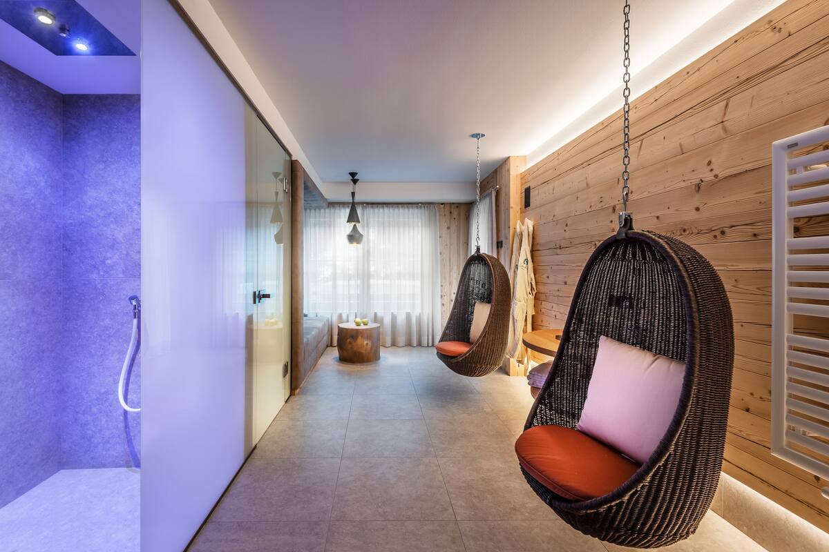 Un couloir moderne avec des chaises suspendues, une douche en verre et un mur en bois.