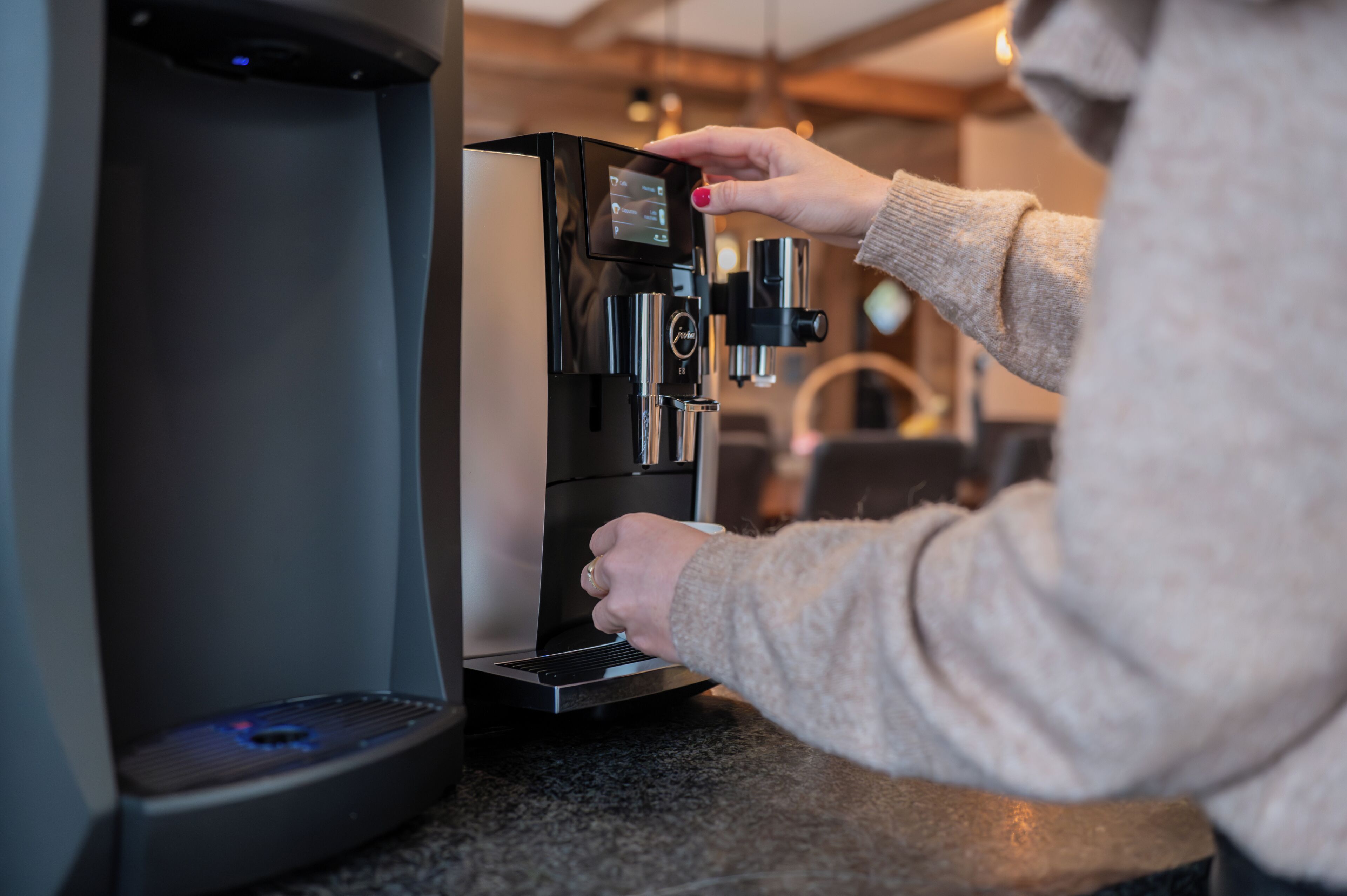 Iemand bedient een koffieapparaat, waarschijnlijk in een café of restaurant.