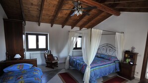 Un dormitorio con dos camas, techo de madera, una ventana y un radiador.