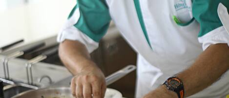 A chef preparing a dish with shrimp and lime in a kitchen.