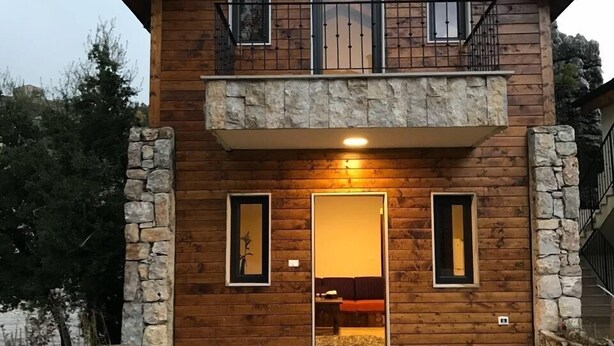 A wooden house with a stone foundation, a balcony, and a door leading to an interior space. - Villars (Mayrouba)
