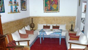 A living room with a sofa set, a coffee table, and a patterned rug. - Riad Dar Latifa (Essaouira)