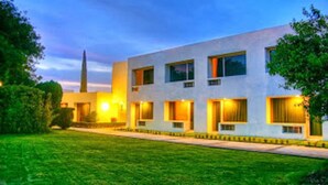A modern building with a flat roof, rectangular windows, and a well-maintained lawn. - Hotel Paradise Inn (Ciudad Victoria)