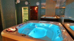 Ein Whirlpool mit Bedienfeld, einer Holzbank und einer gefliesten Wand mit einer Tür zu einem anderen Raum.