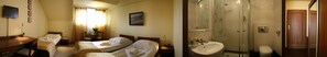 A hotel room with two beds, a desk, a TV, and a bathroom with a shower and toilet. - Hotel Vesta (Jelesnia)
