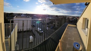 A balcony with a view of a parking lot and buildings in the distance. - Hotel Michael (Gerasdorf bei Wien)