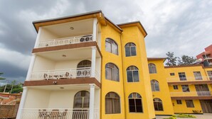 A multi-story building with balconies and a courtyard. - PCG Gishushu Apartment (Kigali)