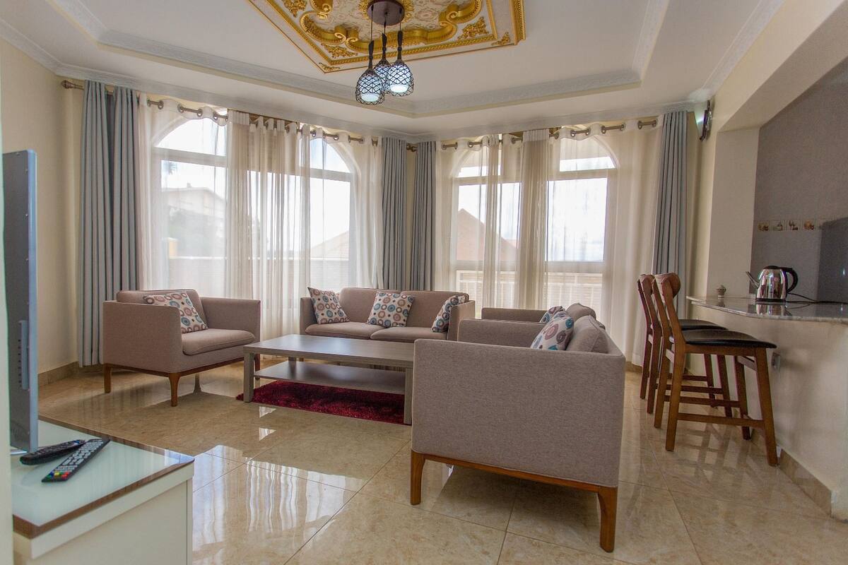 Un amplio salón con un conjunto de sofás, una mesa de centro y una zona de comedor con sillas y una mesa.