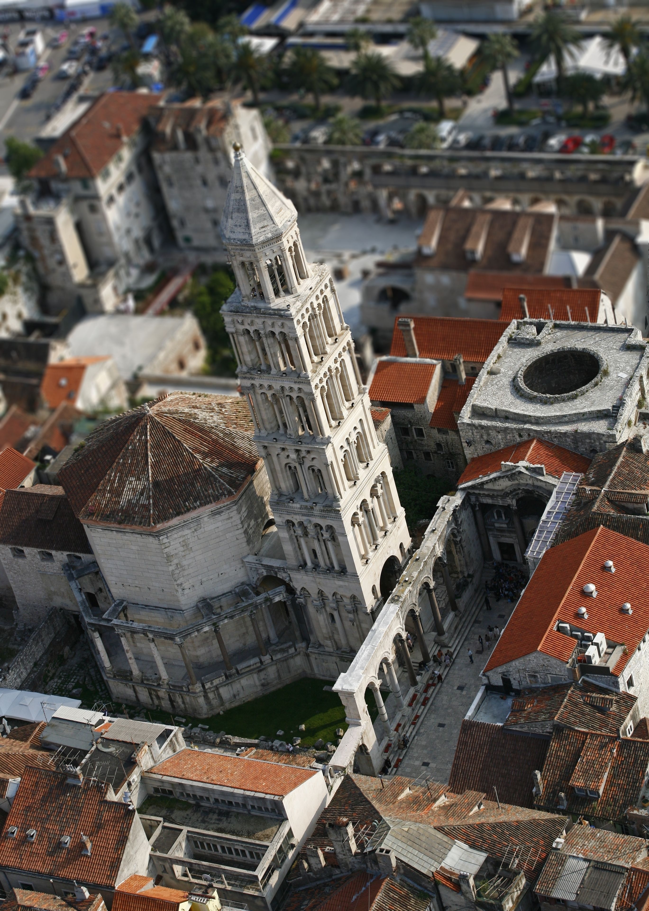 Un bâtiment historique doté d’un imposant clocher et d’un dôme circulaire, entouré d’une architecture traditionnelle avec des toits recouverts de tuiles rouges.