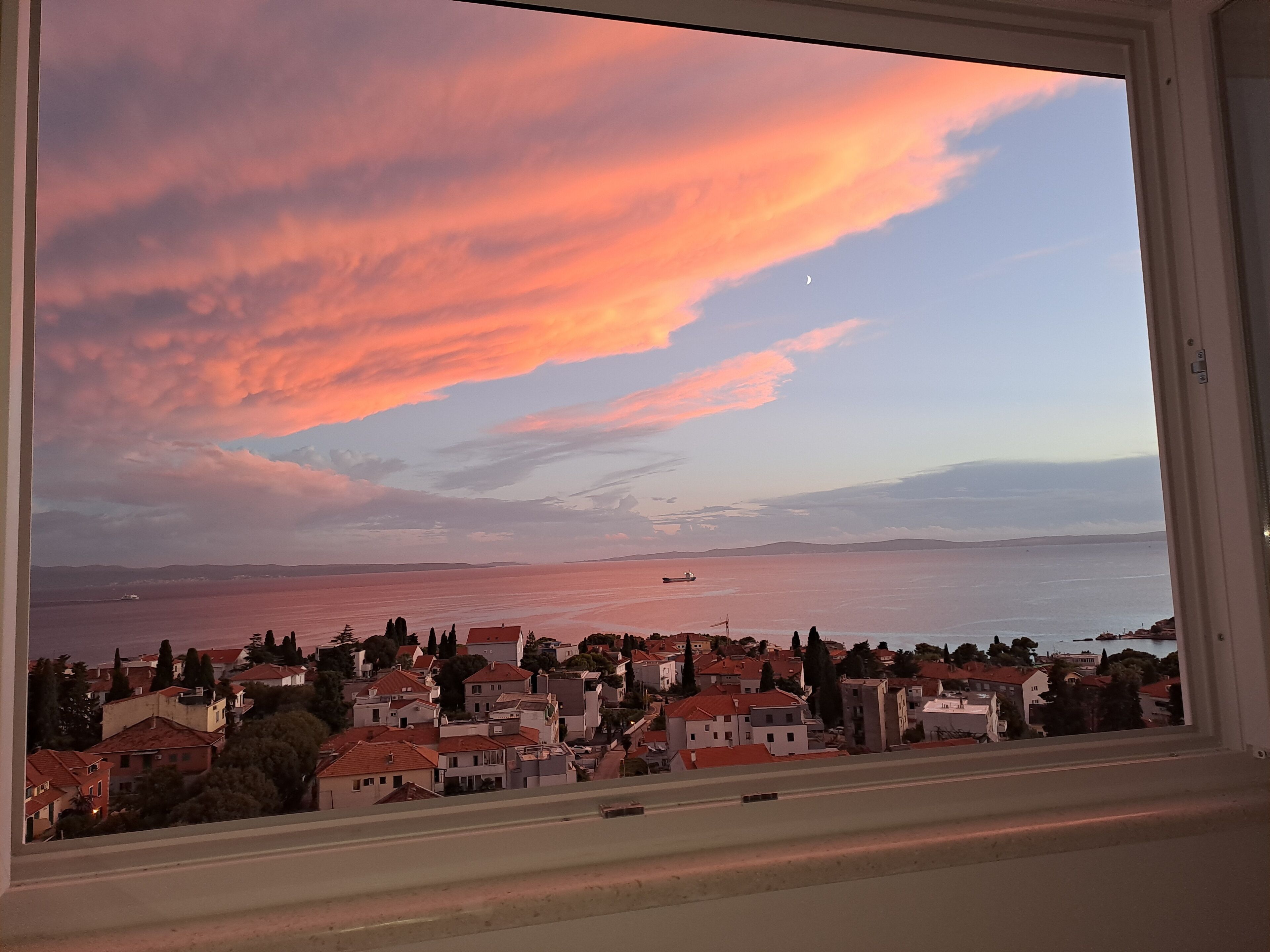 Un borgo costiero con vista sul mare e un tramonto.