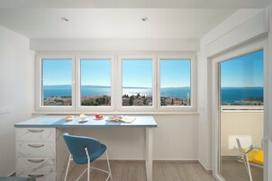 Eine moderne Küche mit einem großen Fenster und Blick auf die Küste.