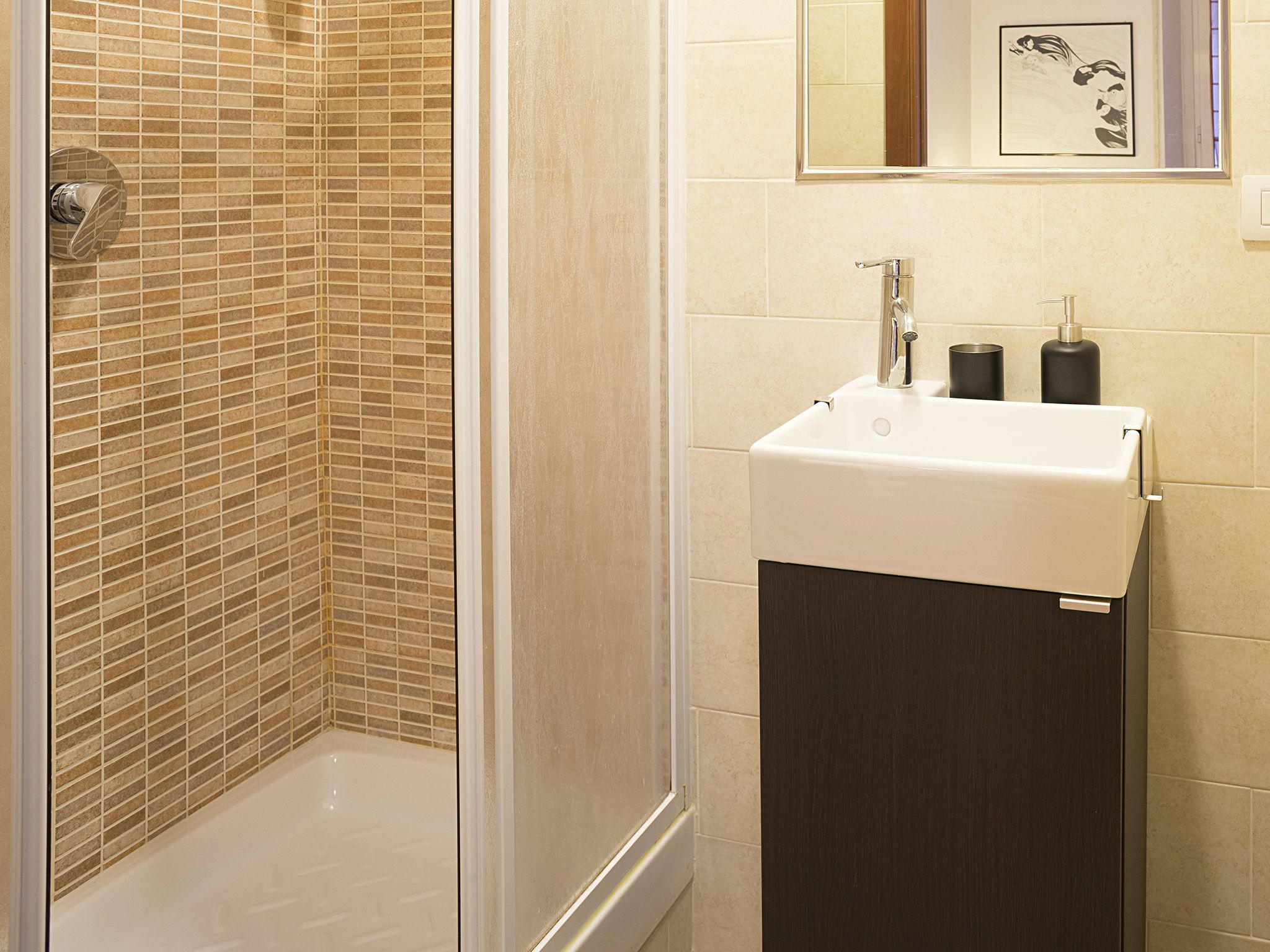 A bathroom with a shower, a sink, and a mirror.