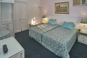 A bedroom with a bed, two bedside tables, a nightstand, a desk, and a chair. - B&B El Olivar (Lima)