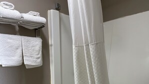 A bathroom with a toilet, bathtub, and shower curtain. - Royal Motel (Martinsville)