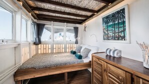 Una camera accogliente con un letto e una scrivania in legno, e un'ampia finestra vista.