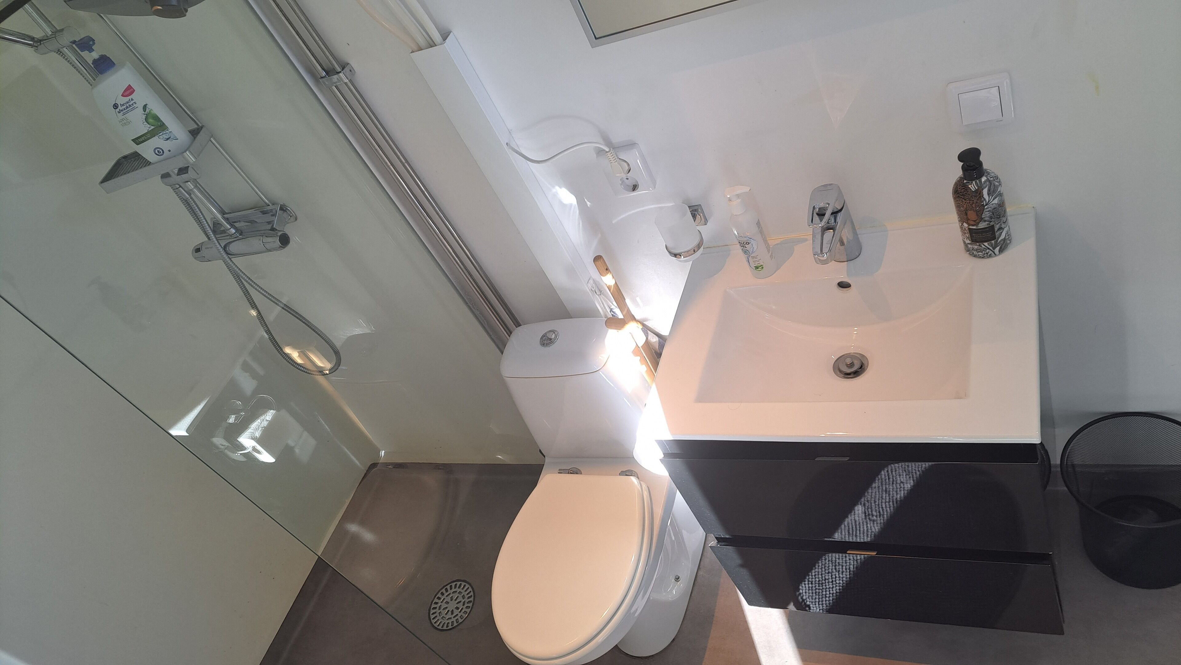 A modern bathroom with a toilet, sink, and shower.