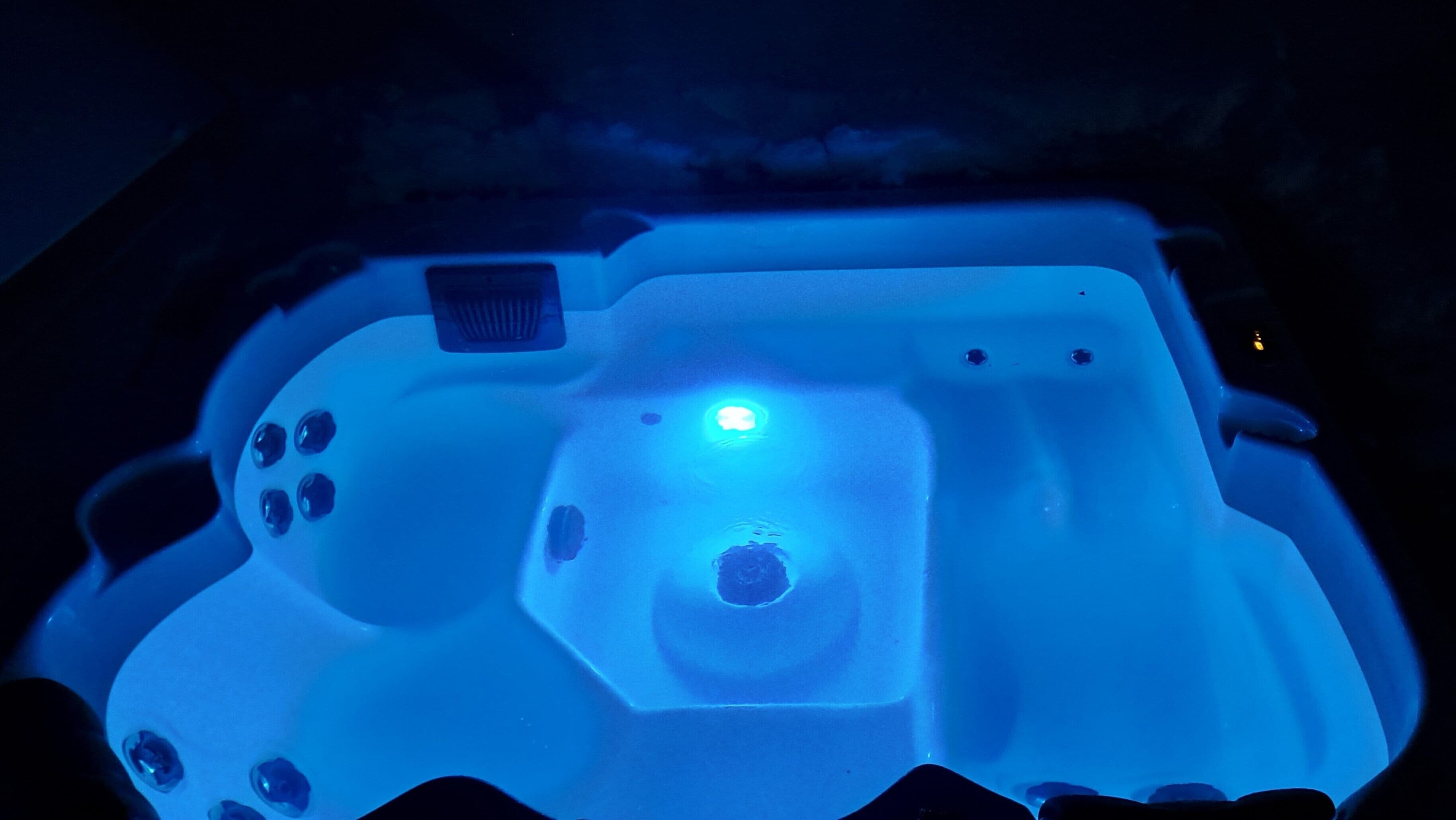 A hot tub with a control panel and a central light.