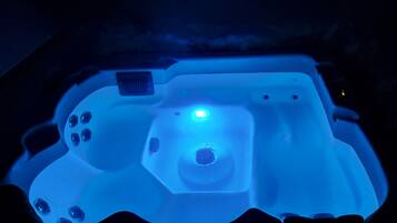 A hot tub with a control panel and a central light.