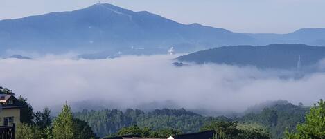 A mountain landscape with houses in the foreground and a clear sky.