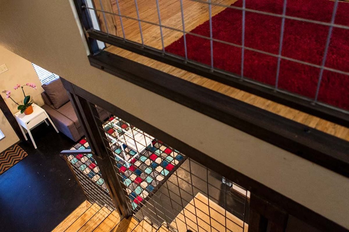 Une vue depuis un balcon donnant sur un tapis à motifs et un plancher en bois.