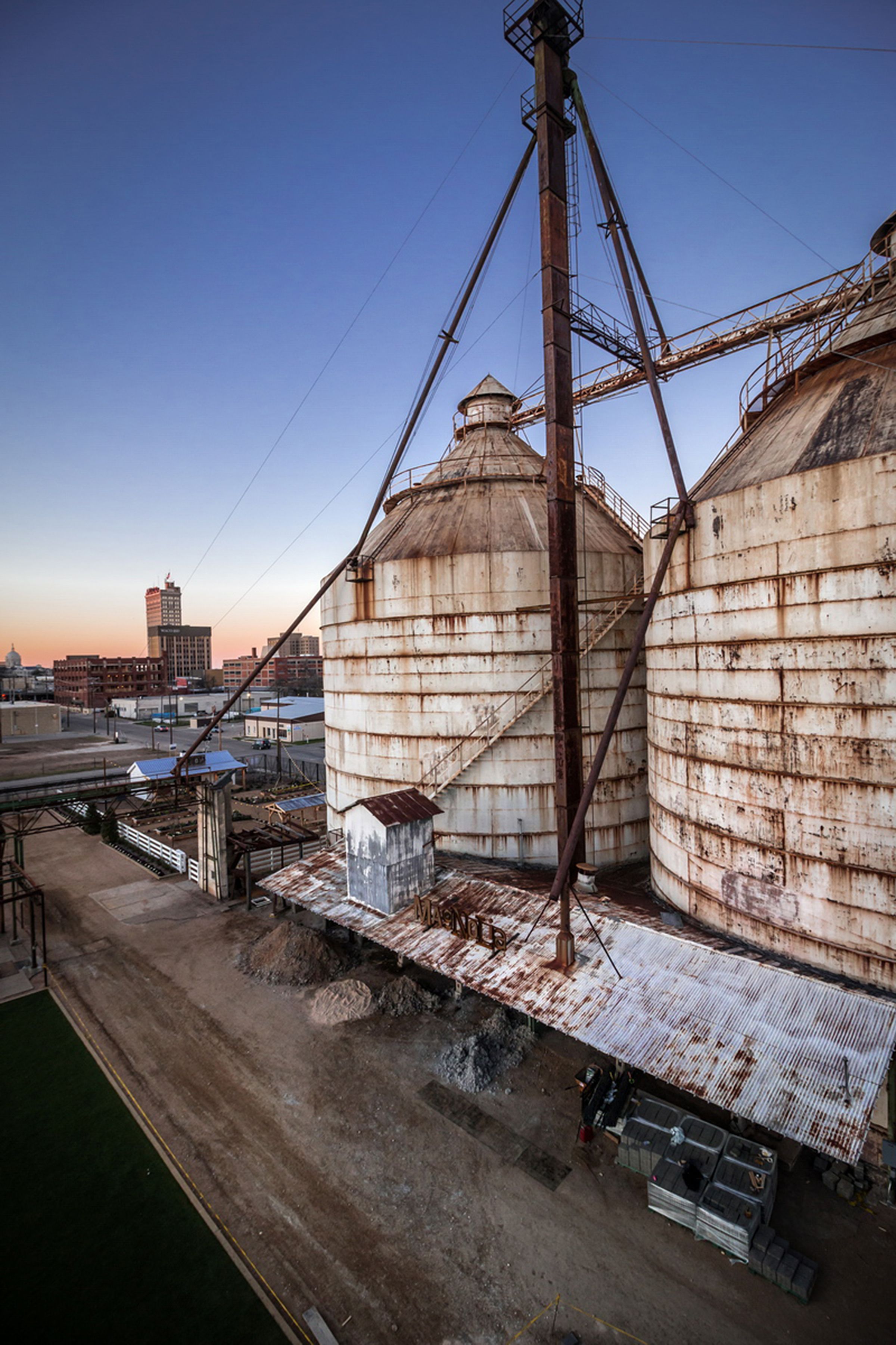 Large industrial silos with a metal staircase leading up to the top.