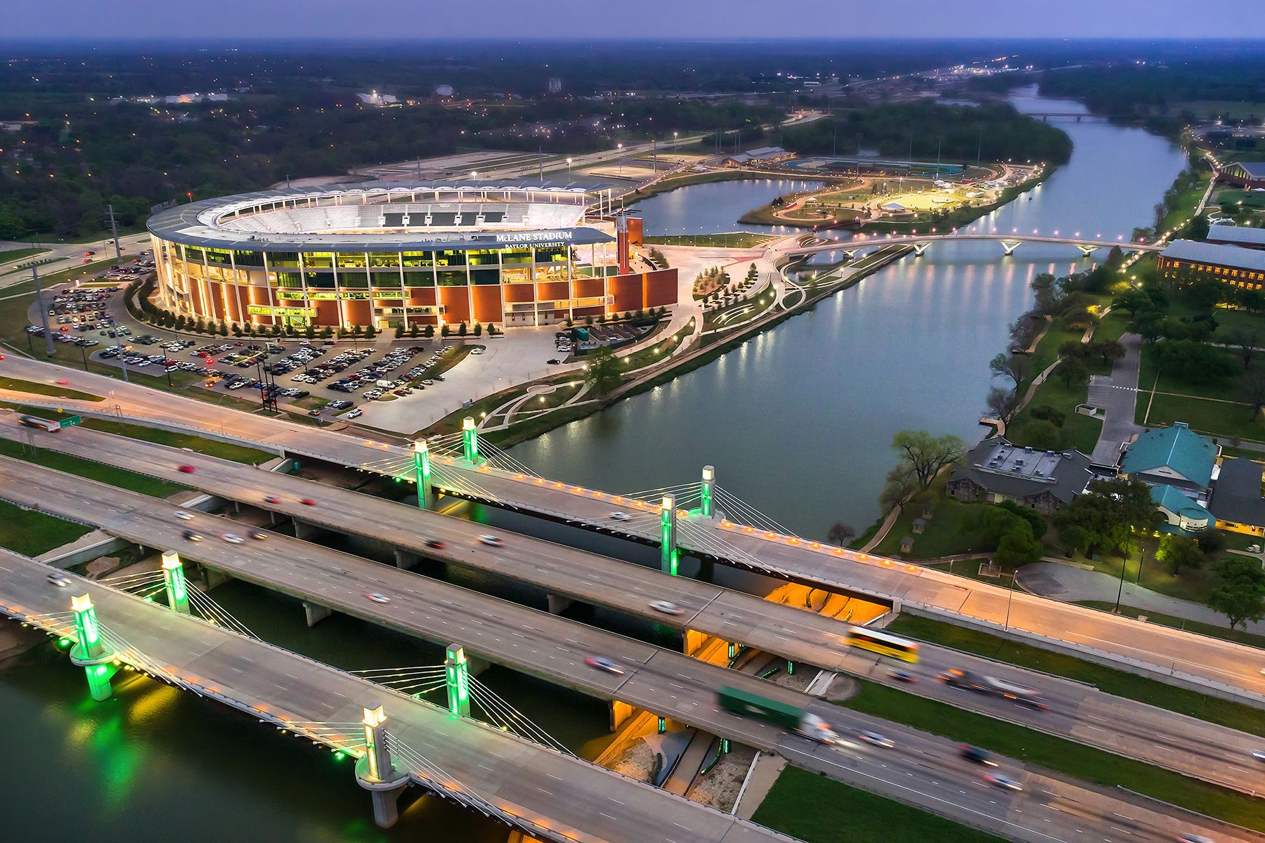 A stadium with multiple levels of seating, connected by bridges over a river.