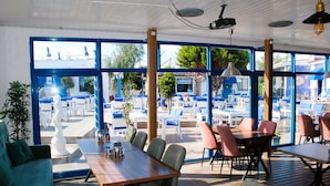 Un restaurante con amplios ventanales, mesas y sillas de madera.