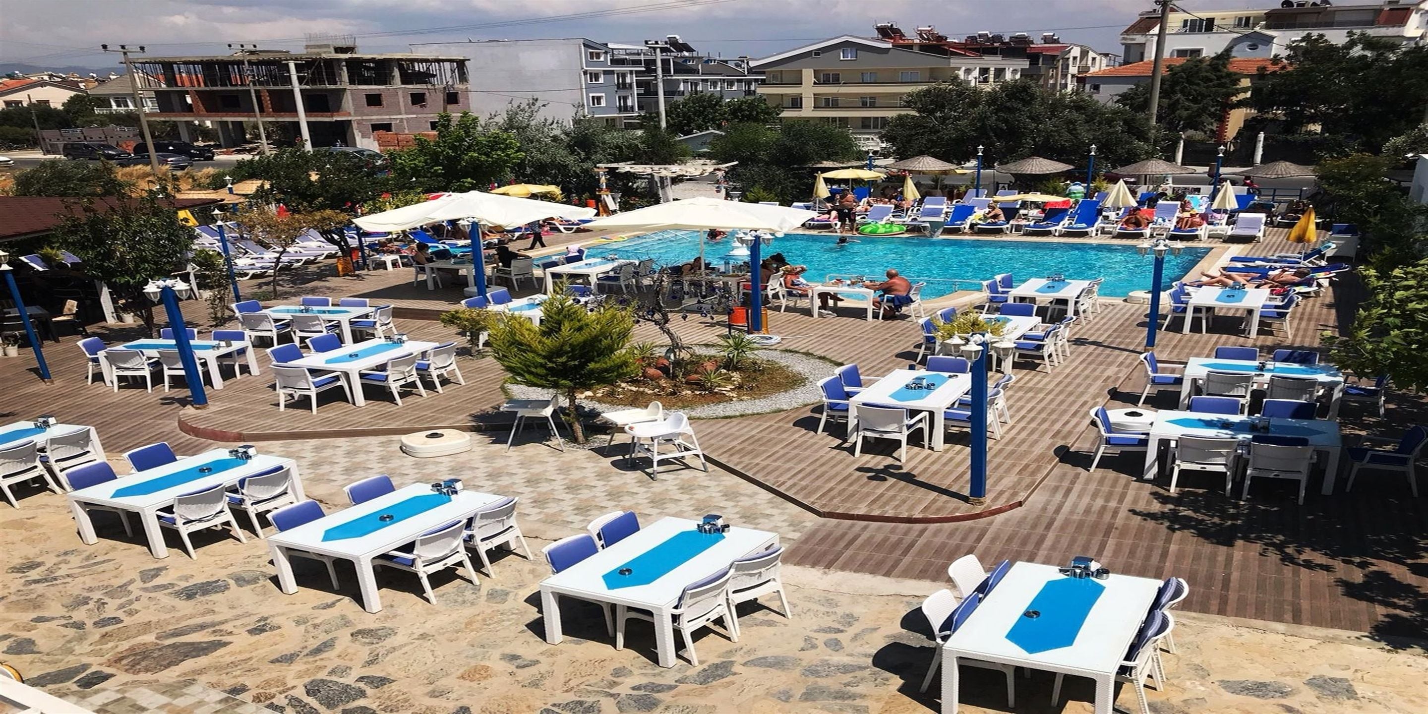 A poolside area with sun loungers, umbrellas, and a swimming pool.