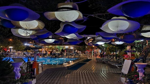 Un área de piscina al aire libre con un diseño de techo único, que presenta grandes estructuras azules con forma de cuenco.