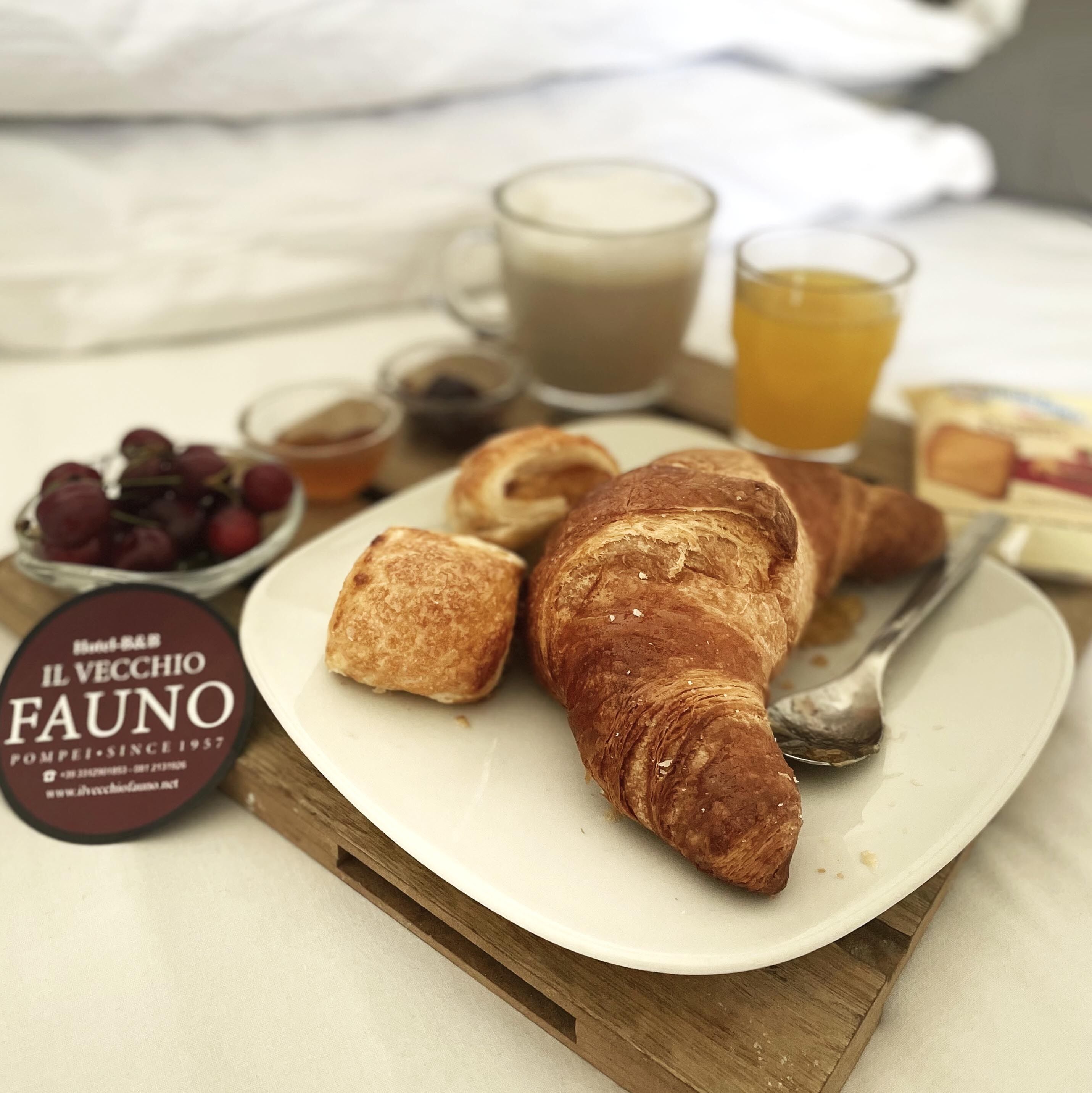 A breakfast tray with croissants, a glass of orange juice, and a cup of coffee.