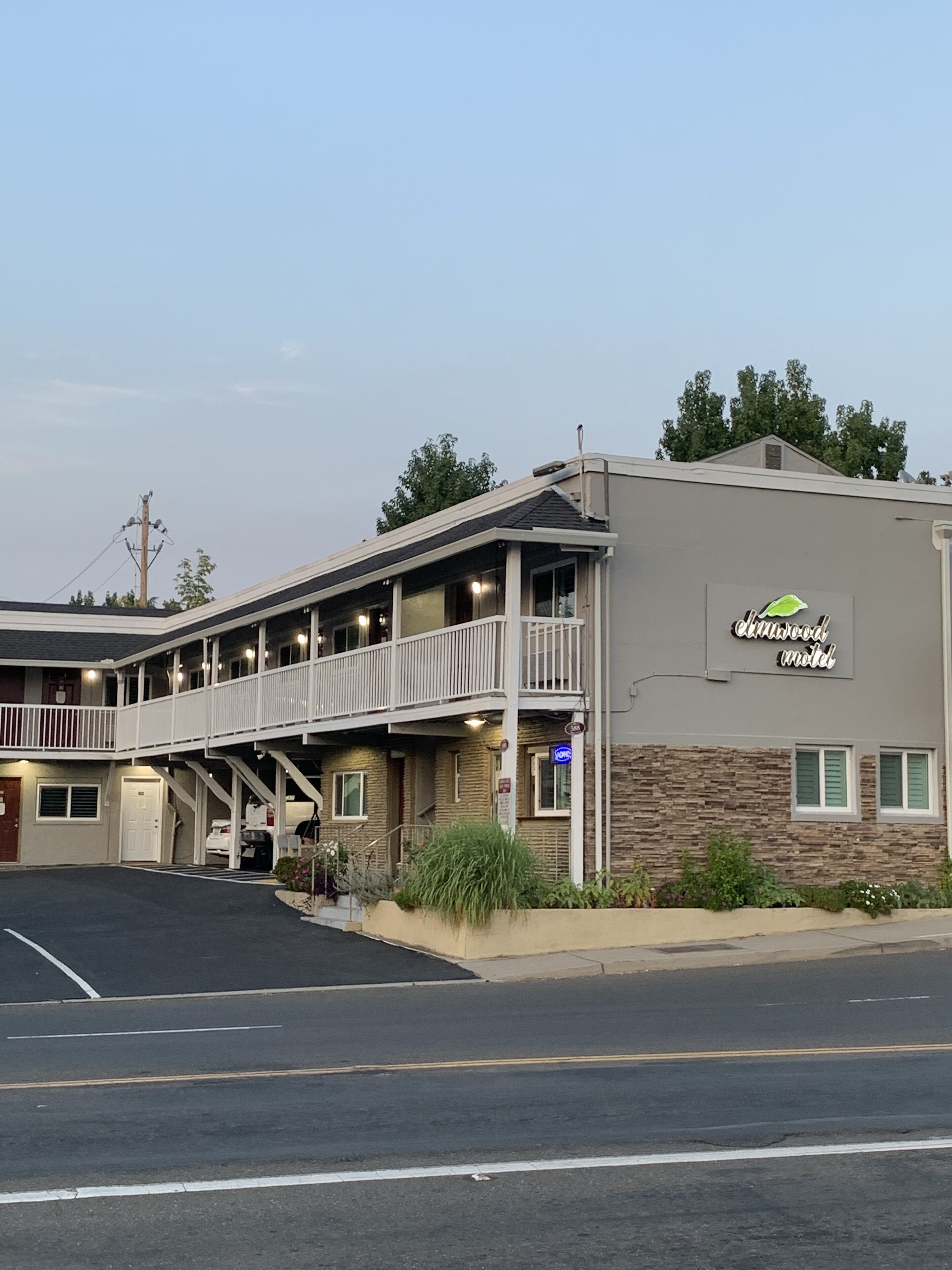 Un motel de dos pisos, con un corredor cubierto y un letrero que indica que es el Shamrock Motel.
