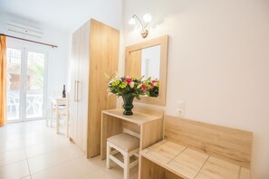Un bagno moderno con un mobile bagno in legno, uno specchio e un vaso di fiori.