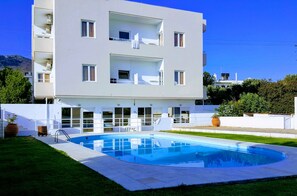 Un moderno edificio a più piani con una piscina in primo piano.